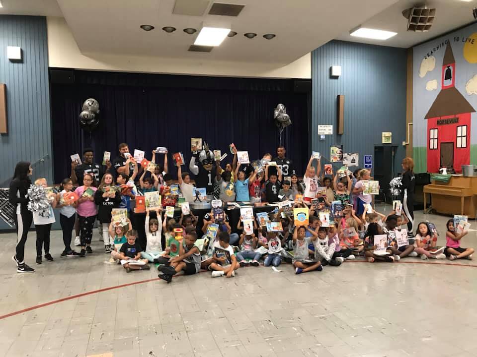 Los Oakland Raiders donan libros nuevos a 85 niños de bajos ingresos en el Centro de Desarrollo Infantil Roosevelt de Davis Street